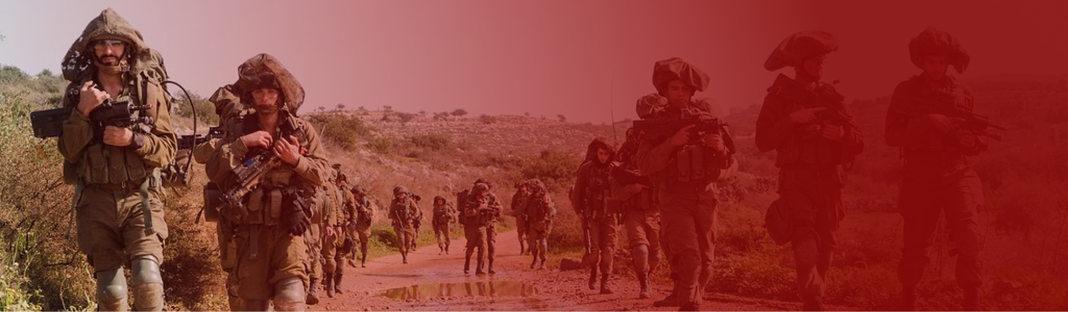 troops in a line moving forward on a desert road